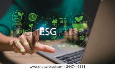 A person is pointing at a laptop screen with the word ESG on it. Concept of sustainability and environmental responsibility