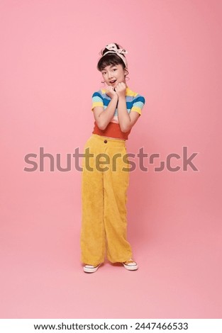 portrait little asian girl smiling cheerful cute looking camera isolated on pink background.
