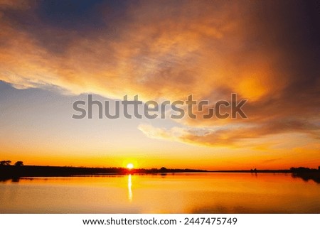 Attractive view of the sunset over the calm surface of the water. Dramatic overcast sky. Location place Ukraine, Europe. Perfect photo wallpaper. Image of exotic scene. Discover the beauty of earth.