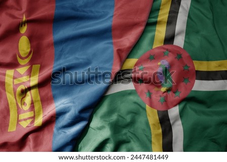 big waving national colorful flag of dominica and national flag of mongolia. macro