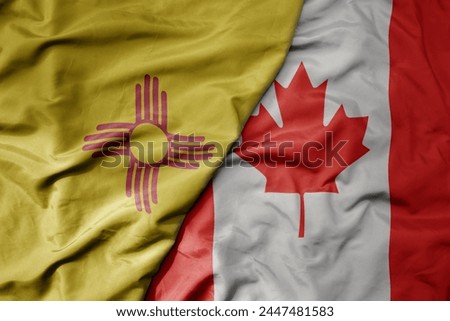 big waving realistic national colorful flag of new mexico state and national flag of canada . macro