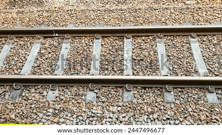 Photo of railroad tracks running diagonally through the picture with partially visible platform