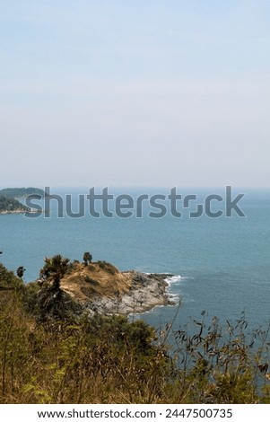 Image of a landscape in Phuket, Thailand near Promthep Cape, a beautiful seaside rock formation and blue waters.