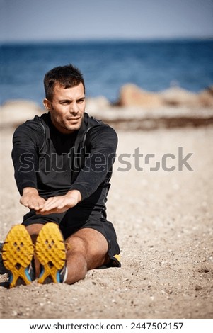Male person, stretching and sports at beach for exercise with fitness warm up, sand and outdoor sunshine. Man, training and nature by ocean with workout for wellness, strong body and health activity