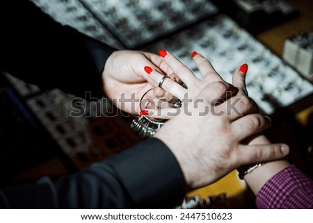 A man carefully slides a beautiful wedding ring onto the womans slender finger, a romantic gesture symbolizing their love and commitment
