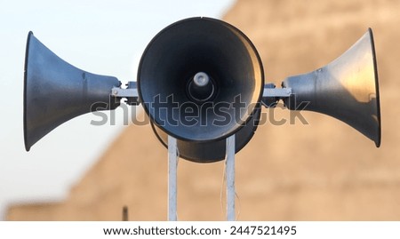three intricately designed loudspeakers set against a blurred background, alarm, emergency siron,mosque speaker ,public speaker,siren,siren speakers,four siren speaker Royalty-Free Stock Photo #2447521495