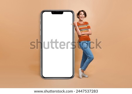 Full size portrait of cheerful charming girl look direct finger empty space ad placard isolated on beige color background