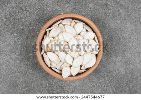 Pumpkin seeds. Dry pumpkin seeds in the ceramic bowl. High-quality photo.