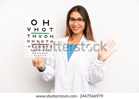 asian young woman smiling happily, waving hand, welcoming and greeting you. optical vision test concept