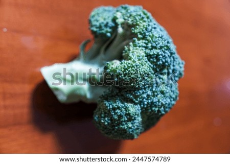 Green broccoli vegetable, on brown wooden background, stock photo.