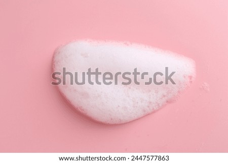 Sample of fluffy foam on pink background, top view