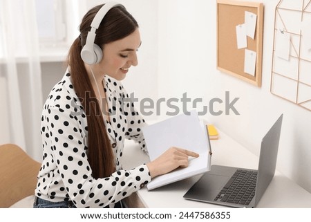 E-learning. Young woman using laptop during online lesson at table indoors