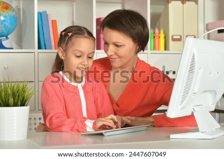 Close up porait of mother and daughter using laptop. High quality photo