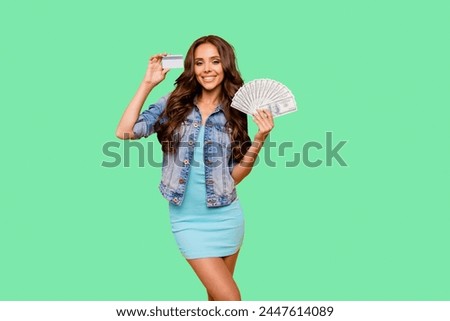 Close up photo beautiful her she lady hold credit card fan money I am wealthy self-confident bossy stunning wear blue teal green short dress jeans denim jacket clothes isolated yellow background