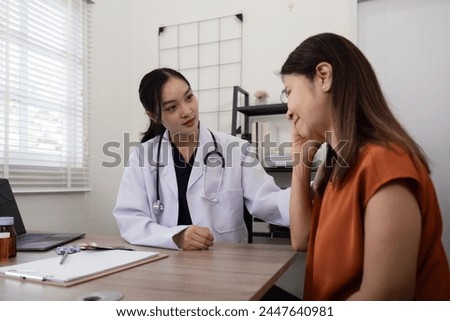 A female doctor asks about the symptom of an elderly female patient who is suffering from stress or headache. and holding the shoulder to encourage the patient