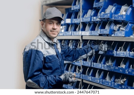 Industrial worker in warehouse of steel fittings for hydraulic hoses in manufacturing factory.