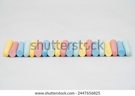The colorful chalk is arranged in such a way that it looks very beautiful against the abstract white background