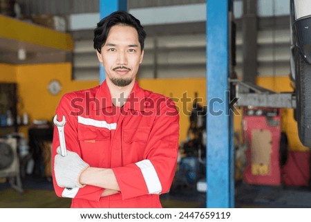 Portrait of male mechanic working at garage. Asian male mechanics at auto car repair service. Car service and Maintenance concept