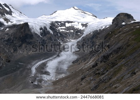 Landscape photo with a view of part of the Grossglockner mountain covered with snow and glacier against a stormy sky in the Hohe Tauern National Park, Tyrol, Austria