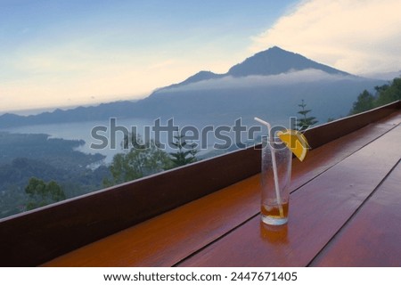  Enjoy the beautiful afternoon view of the Batur Mountains and Lake in Kintamani with a glass of warm tea.  Located in Kintamani, Bali. Indonesian.