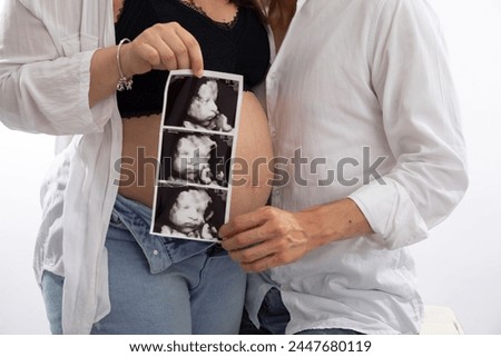 Big Pregnant belly with echography showing baby picture motherhood