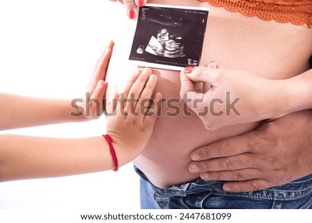 Big Pregnant belly with ultrasound echography showing baby picture motherhood