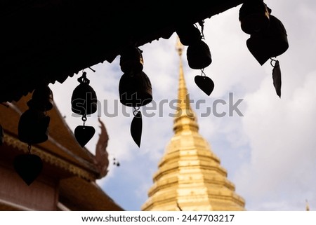 A row of bells hanging from a building, Wat Phra That Doi Suthep The bells are hanging from a wooden structure and are of different sizes