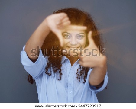 Smiling attractive young business woman in blue shirt posing on gray background