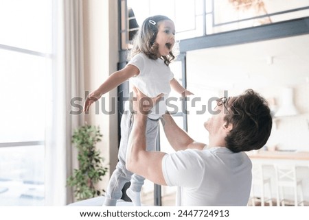 Excited young happy father and little daughter playing and having fun together. Family time, father`s day celebration, parenthood and fatherhood. I love you, dad! Royalty-Free Stock Photo #2447724913