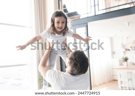 Active cheerful young happy father and small daughter playing and having fun together. Family time, father`s day celebration, parenthood and fatherhood. I love you, dad! Royalty-Free Stock Photo #2447724915