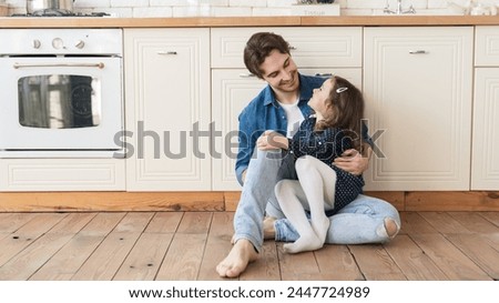 Happy cheerful family spending time together, father and his little daughter having fun, playing in the kitchen. Family time, father`s day. Parenthood and fatherhood Royalty-Free Stock Photo #2447724989