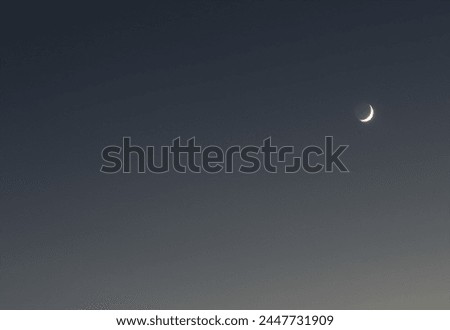 Modern looking minimalist ombre night sky with crescent moon shining down.  Contemporary photo.  Room for text.  