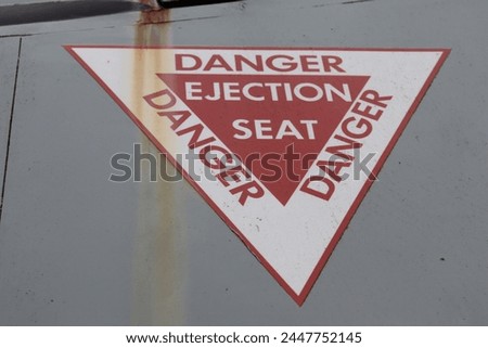 military airplane danger ejection seat sign on the side of a plane Royalty-Free Stock Photo #2447752145