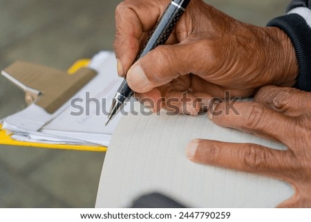 Person writing a text on a sheet of paper