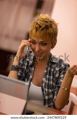 Engaged in a delightful call, she divides her attention between the joy of conversation and work.