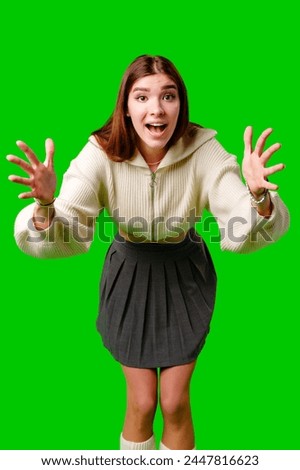Young Woman Gesturing Excitement in Casual Attire Against Green Screen Backdrop