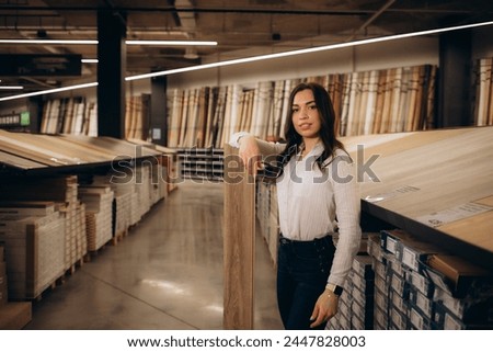 Woman chooses laminate flooring in hardware store. High quality photo