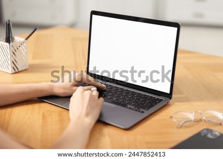 Young woman watching webinar at table indoors, closeup