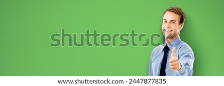 Portrait image - smiling confident businessman business man show thumbs up like hand sign gesture, isolated against green chroma key background. Happy confident man gesturing. Free ad text area. Adver