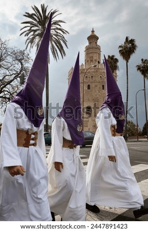 Penitents during Semana Santa (Holy Week) beneath Torre del Oro, Seville, Andalucia, Spain, Europe Royalty-Free Stock Photo #2447891423