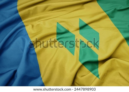 waving colorful national flag of saint vincent and the grenadines. macro shot