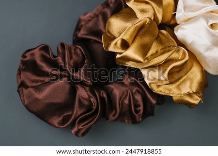 Three Scrunchies in Different Colors on Gray Background