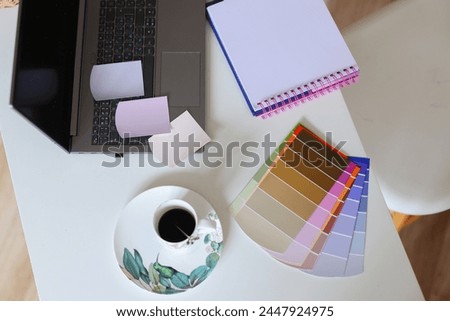 Computer, pen tablet, color swatches and sketches on a designer's workspace with a very shallow depth of field