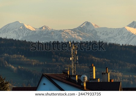 Antenna on building roof with and mountains on a background at sunset time 