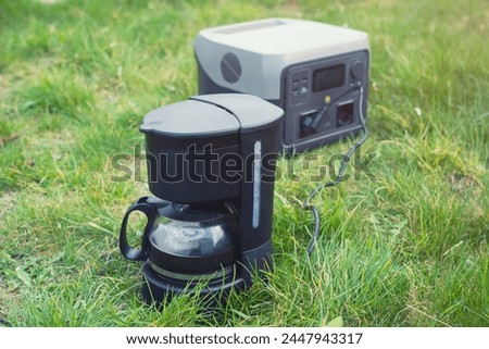 Ground coffee cooking using an electrical dripper and portable power station. The maintenance or camping equipment. Royalty-Free Stock Photo #2447943317