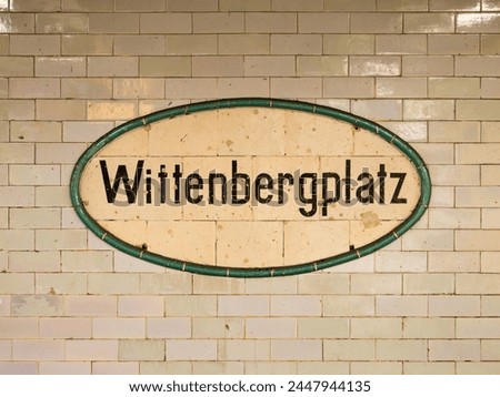 Wittenbergplatz station sign in Berlin. The location signage of the public transportation is part of the underground. The tiled wall is weathered and old.
