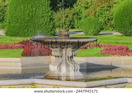 It's view of fountain and the flowersbed in park. It is photo park in sunny
day