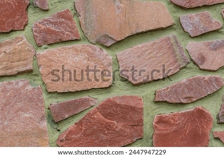 It's photo of colorful stones on green background. It is close up of multicolored stone wall of building. Its the photo of mosaic stone tile floor
