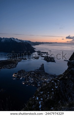 Views from top of Reinebringen mountain hike in Lofoten, Norway.  Snow covered mountains captured at sunset by a mirrorless camera.  Located far North in the Arctic Circle.  A famous Lofoten hike.
