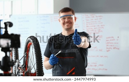 Bicycle repairman in workshop holding thumbs up. Quality bike repair concept